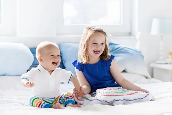 Kinder spielen auf dem Bett der Eltern — Stockfoto