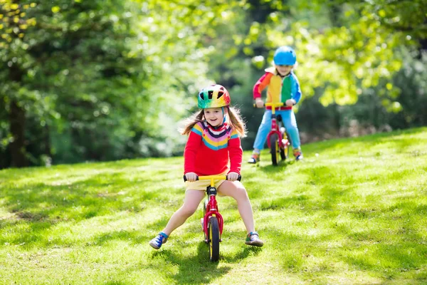 Kids ride balance bike in park