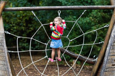 Okul bahçesinde oyun parkında eğlenceli olan çocuğun