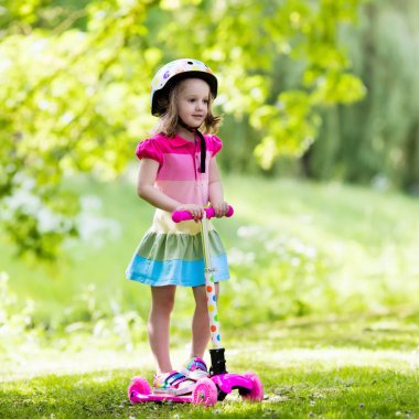 Küçük kız renkli bir scooter sürme