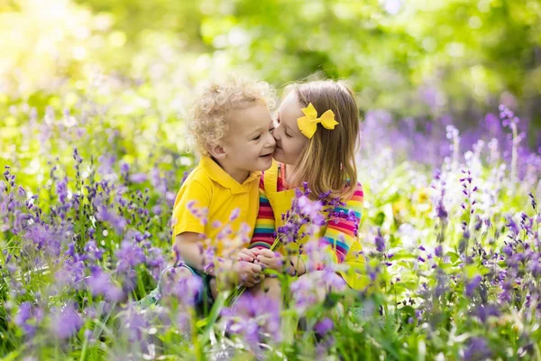 Enfants jouant dans le jardin fleuri avec des fleurs de bluebell — Photo