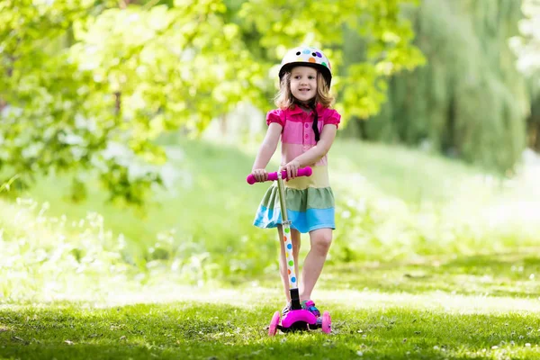 Маленькая девочка на красочном скутере — стоковое фото