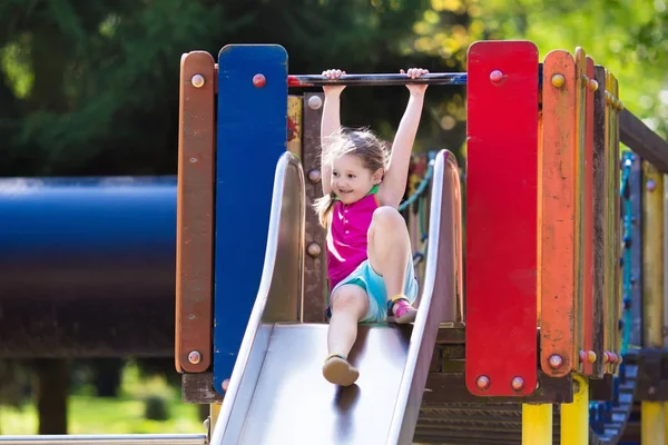 Kind spelen op de speelplaats in de zomer — Stockfoto