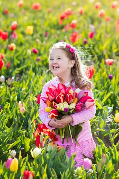 Niña en jardín de flores de tulipán — Foto de Stock