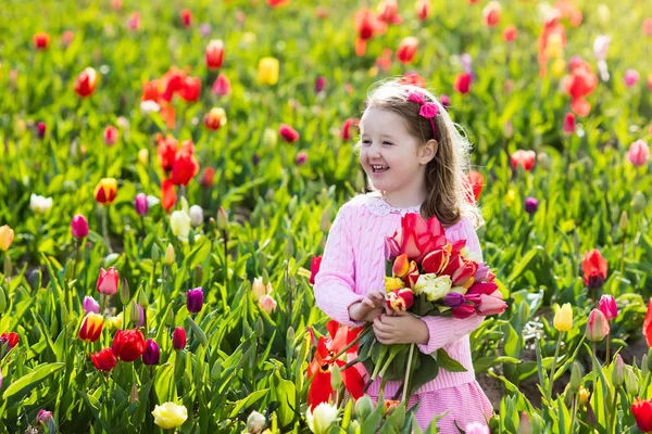 Klein meisje in tulip bloementuin — Stockfoto
