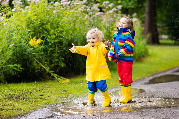 Les enfants jouent sous la pluie et la flaque d'eau en automne — Photo