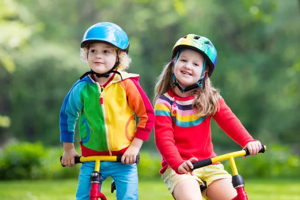 Kids ride balance bike in park