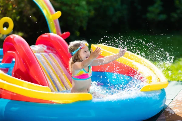 Criança na piscina do jardim com slide — Fotografia de Stock