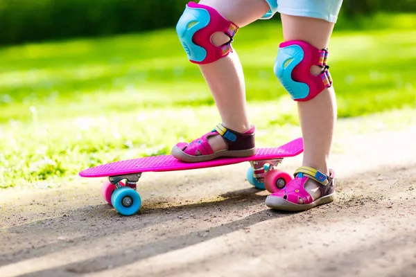 Kind paardrijden skateboard in zomer park — Stockfoto