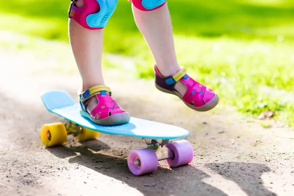 Kind paardrijden skateboard in zomer park — Stockfoto