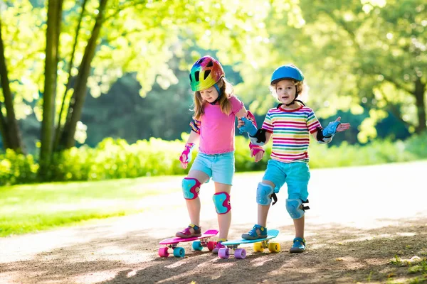 Děti na koni skateboard v letním parku — Stock fotografie