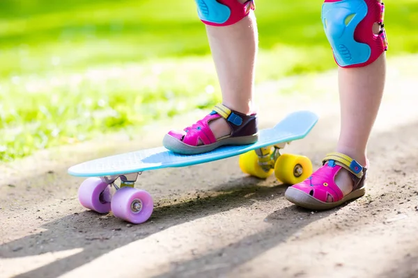 Kind paardrijden skateboard in zomer park — Stockfoto