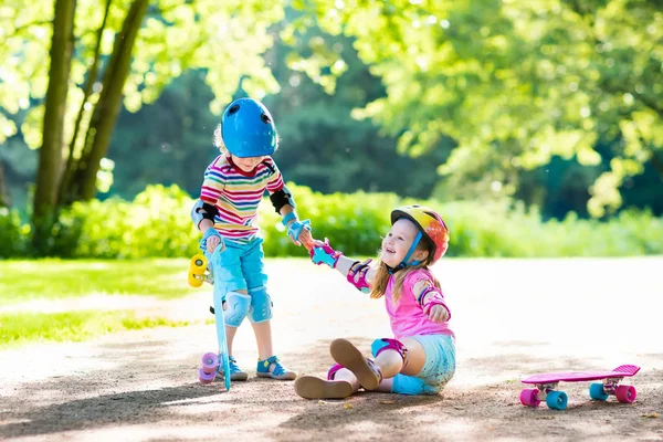 Bambini che cavalcano lo skateboard nel parco estivo — Foto Stock