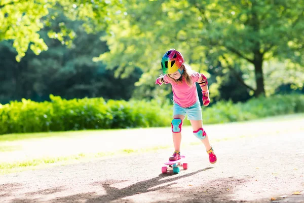 Børne ridning skateboard i sommerpark - Stock-foto