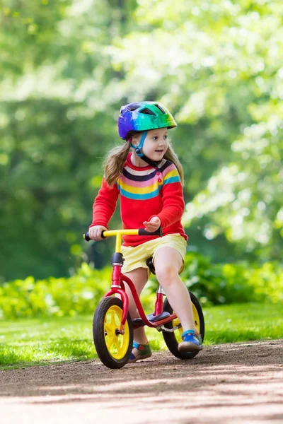 Kids ride balance bike in park