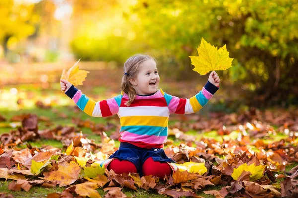 Kind in Val park. Kind met herfst bladeren. — Stockfoto