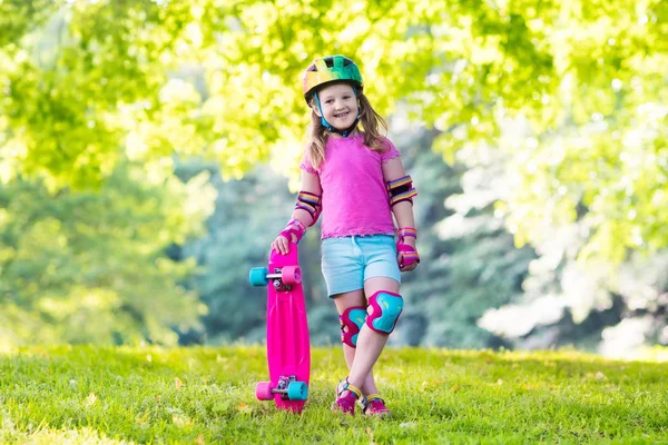 Børne ridning skateboard i sommerpark - Stock-foto