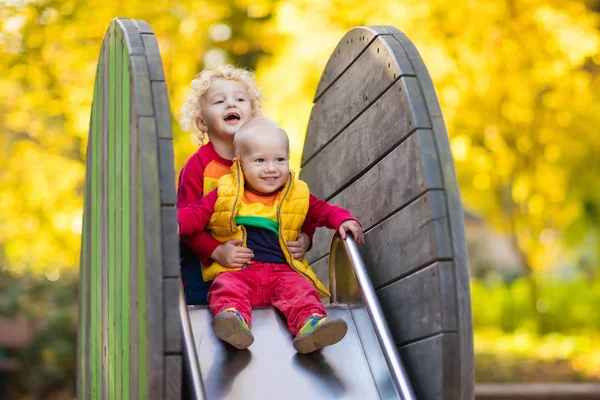 Bambino nel parco giochi in autunno. Bambini in autunno . — Foto Stock