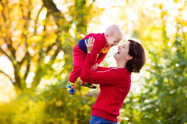 Moeder en baby in het najaar. Val buiten familieplezier. — Stockfoto