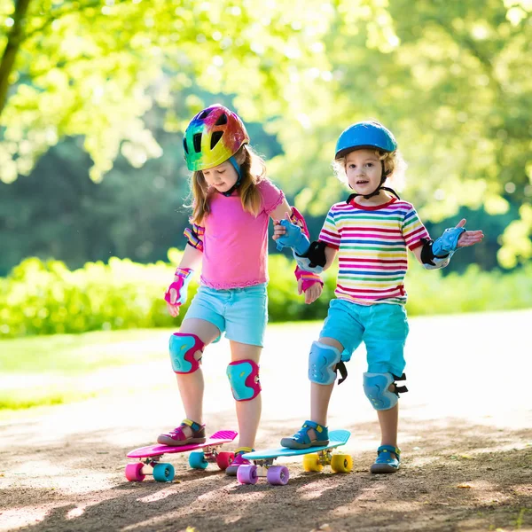 Crianças andando de skate no parque de verão — Fotografia de Stock