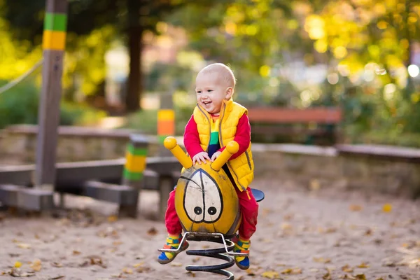 Kind auf Spielplatz im Herbst. Kinder im Herbst. — Stockfoto