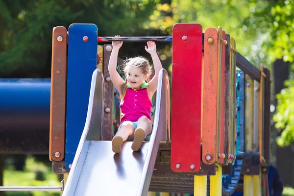 Criança brincando em playground ao ar livre no verão — Fotografia de Stock