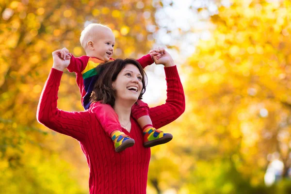 Moeder en baby in het najaar. Val buiten familieplezier. — Stockfoto