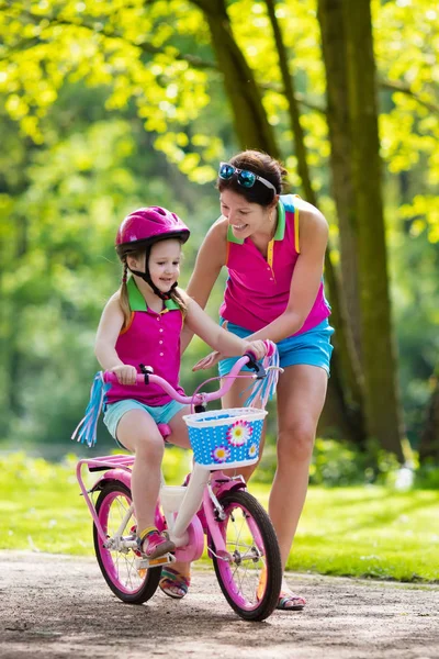 Mother teaching child to ride a bike Royalty Free Stock Images