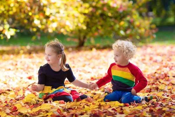 Crianças brincam no parque outono. Crianças em queda. — Fotografia de Stock