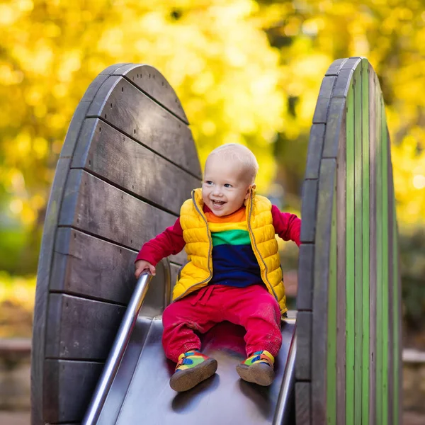 Bambino nel parco giochi in autunno. Bambini in autunno . — Foto Stock