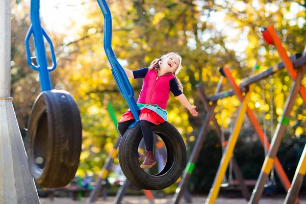 Bambino nel parco giochi in autunno. Bambini in autunno . — Foto Stock