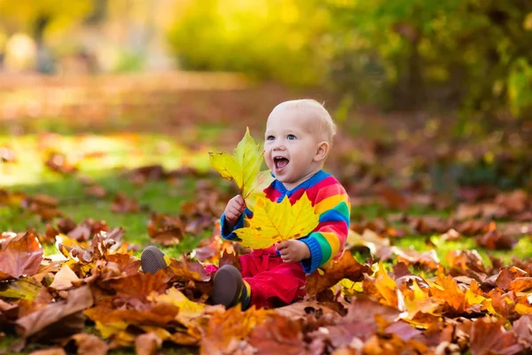 Barn i höst park. Kid med hösten lämnar. — Stockfoto