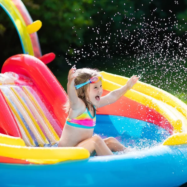 Criança na piscina do jardim com slide — Fotografia de Stock