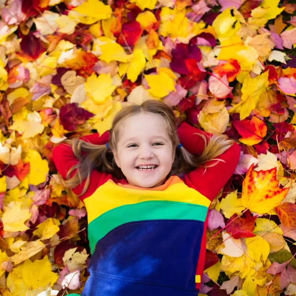 Barn i höst park. Kid med hösten lämnar. — Stockfoto