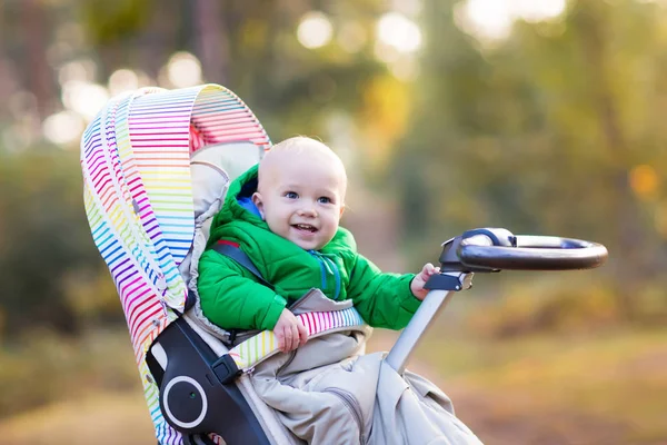 Niño en cochecito en el parque de otoño — Foto de Stock