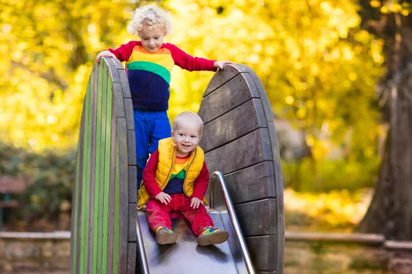 Bambino nel parco giochi in autunno. Bambini in autunno . — Foto Stock