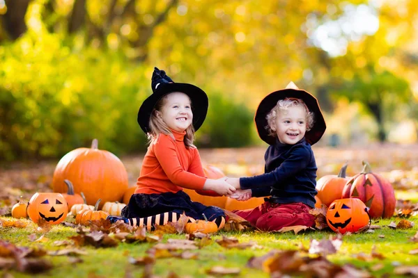 Kids with pumpkins in Halloween costumes — Stock Photo, Image