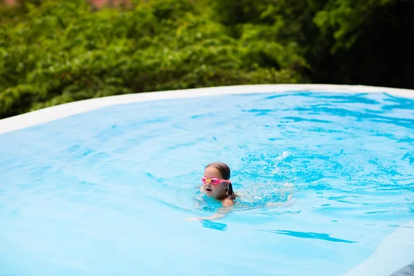 Bambino con occhiali in piscina. I bambini nuotano . — Foto Stock