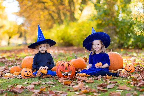 Crianças com abóboras em trajes de Halloween — Fotografia de Stock