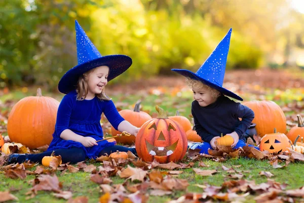 Crianças com abóboras em trajes de Halloween — Fotografia de Stock