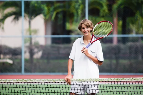 Enfant jouant au tennis sur un court extérieur — Photo