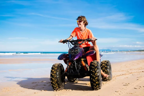 Tiener rijden quad bike op strand — Stockfoto