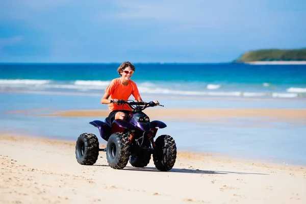 Tiener rijden quad bike op strand — Stockfoto