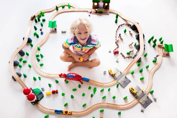 Kind met speelgoed trein. Houten spoorlijn van kinderen. — Stockfoto