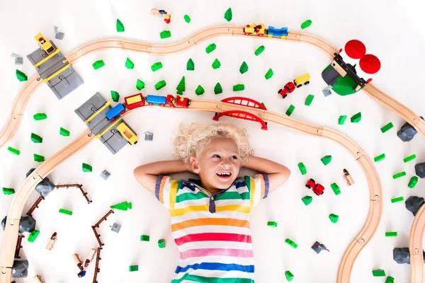 Niño con tren de juguete. Ferrocarril de madera . — Foto de Stock