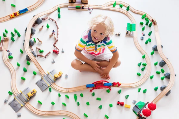 Criança com trem de brinquedo. Crianças ferroviário de madeira . — Fotografia de Stock