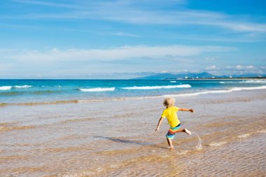 Çocuk tropik sahilde. Deniz tatil çocuklarla.