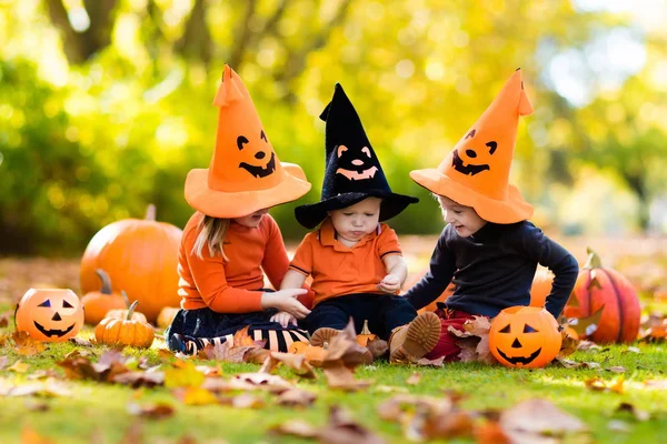 Enfants avec des citrouilles en costumes d'Halloween — Photo
