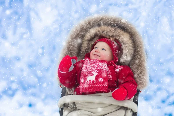 Baby in kinderwagen in winter park met sneeuw — Stockfoto