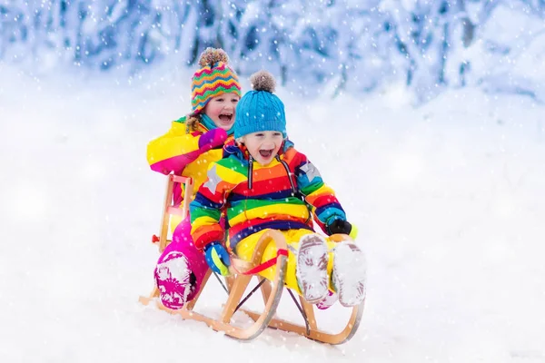 Barnen leker i snön. Vinter slädtur för barn — Stockfoto